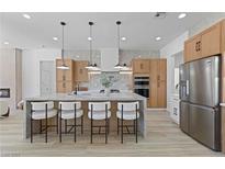 Modern kitchen features a marble island with seating, stainless steel appliances and light wood cabinets at 2317 Sierra Heights Dr, Las Vegas, NV 89134