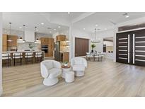 Open-concept living room with a view of a modern kitchen, breakfast nook, and stylish decor with light flooring at 2317 Sierra Heights Dr, Las Vegas, NV 89134