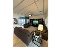 Spacious living room with modern furniture, fan and a large entertainment center, perfect for relaxing at 9373 Oxbow Lake Ave, Las Vegas, NV 89149