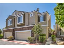 Charming townhome with a combination of stucco and brick exterior, plus a two-car garage and landscaped front yard at 939 Paisley St, Las Vegas, NV 89145