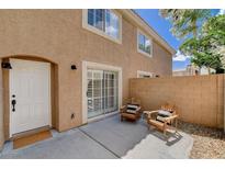 Private patio featuring two wooden chairs with cushions and a sliding glass door leading inside at 9655 Lame Horse Dr, Las Vegas, NV 89123