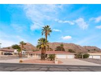 Expansive single-story home with lush landscaping, circular driveway, and mountain views at 1108 Sidehill Way, Las Vegas, NV 89110