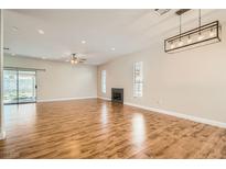 Bright living room boasts wood floors, fireplace, and modern light fixture at 5921 Royal Castle Ln, Las Vegas, NV 89130