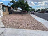 View of the residence showcasing the desert landscaping and mature shade tree at 805 Slayton Dr, Las Vegas, NV 89107