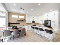 Bright kitchen featuring white cabinetry, stainless steel appliances, and a large island with seating at 9813 Folsom Dr, Las Vegas, NV 89134