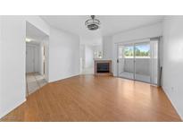 Bright living room featuring wood floors, a fireplace, and a sliding glass door to outdoor space at 10116 Jacob Pl # 104, Las Vegas, NV 89144