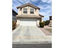Charming two-story home with a white garage door and desert landscaping at 4708 Grand Rock Dr, North Las Vegas, NV 89081
