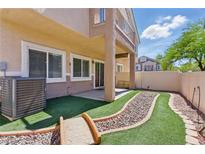 Backyard featuring artificial turf and a decorative rock garden at 1069 Thrill Ct # 102, Henderson, NV 89002