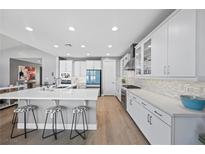Bright kitchen features a large island with seating, modern appliances, and white cabinets at 8440 Footpath St, Las Vegas, NV 89166
