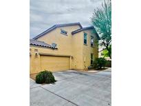 Two-story home with neutral exterior, attached garage, and well-maintained landscaping at 4590 Lime Straight Dr, Las Vegas, NV 89115