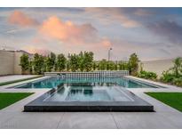 Stunning pool with integrated spa and modern black and white diamond tile accents, surrounded by lush landscaping at 11990 Montague St, Las Vegas, NV 89138