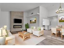 Staged living room with fireplace, white sofas, dining table and kitchen view at 2851 S Valley View Blvd # 1098, Las Vegas, NV 89102