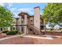 Exterior view of charming two-story condo with red rock landscaping at 1575 W Warm Springs Rd # 121, Henderson, NV 89014