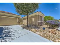 Inviting single-story home showcasing drought-resistant landscaping, neutral tones, and a convenient two-car garage at 2213 Carrier Dove Way, North Las Vegas, NV 89084