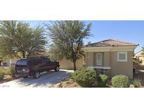 Charming single-story home with a tile roof, desert landscaping, and inviting curb appeal on a sunny day at 2213 Carrier Dove Way, North Las Vegas, NV 89084