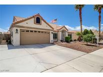 Charming single-story home featuring a two-car garage, landscaped front yard, and an American flag at 2301 Jean Paul Ave, North Las Vegas, NV 89031