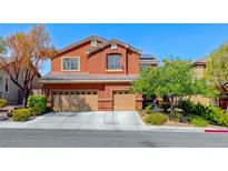 Two-story home featuring a three-car garage, terracotta color scheme, desert landscaping and a blue sky at 2733 Auchmull St, Henderson, NV 89044