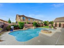 This backyard oasis features a sparkling pool with water feature, a fire pit, and ample patio space at 6442 American Eagle Ave, Las Vegas, NV 89131