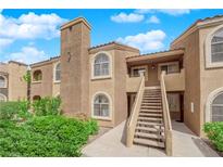 Attractive two-story condo with stucco exterior, balcony, and well-maintained landscaping under a bright, blue sky at 7950 W Flamingo Rd # 2019, Las Vegas, NV 89147