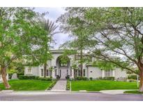 Stunning home exterior showcasing a well-manicured lawn and mature trees, enhancing curb appeal and providing shade at 2338 Dolphin Ct, Henderson, NV 89074