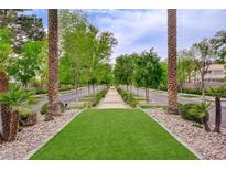 Scenic street view featuring a lush green median with tall palm trees and well-maintained landscaping at 2338 Dolphin Ct, Henderson, NV 89074