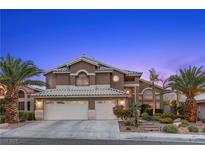 Charming two-story home with a well-manicured front yard and a three-car garage, complemented by mature palm trees at 283 Grand Olympia Dr, Henderson, NV 89012
