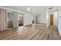 Bright living room featuring wood floors, neutral walls, and a sliding glass door to the balcony at 3425 E Russell Rd # 155, Las Vegas, NV 89120