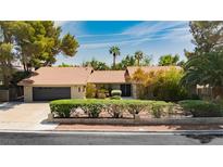 Charming single-story home featuring lush landscaping and a well-manicured lawn on a sunny day at 3007 La Mesa Dr, Henderson, NV 89014