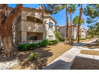 Charming condo exterior with well-maintained landscaping, inviting walkways, and beige stucco at 6480 Annie Oakley Dr # 814, Las Vegas, NV 89120