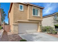 Beige two story home featuring a two-car garage and neatly kept landscape at 11120 Whooping Crane Ln, Las Vegas, NV 89144