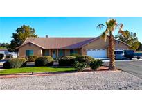 Charming single story house featuring a desert landscaped yard, two-car garage, and a tile roof at 1571 Princeton Cir, Pahrump, NV 89060