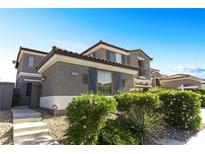 Inviting two-story home featuring a well-maintained lawn, beautiful landscaping, and a security system at 10013 Scenic Walk Ave, Las Vegas, NV 89149