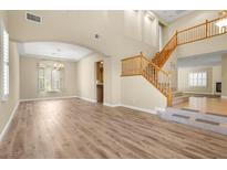 Spacious living room featuring hardwood floors, abundant natural light, and elegant chandelier at 10013 Scenic Walk Ave, Las Vegas, NV 89149
