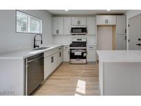 Bright kitchen features stainless steel appliances, white cabinets and quartz countertops at 1304 Virgil St, Las Vegas, NV 89110