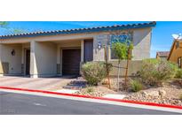 Inviting townhouse featuring a one-car garage, desert landscaping, and a quaint front entrance at 2727 Chinaberry Hill St, Laughlin, NV 89029