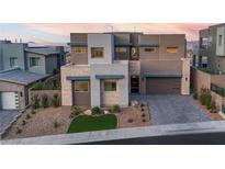 Contemporary two-story home featuring a modern design, stone accents, a well-manicured yard, and an attached garage at 286 Shaded Canyon Dr, Henderson, NV 89012