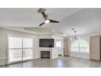 Bright living room features a fireplace, large windows, ceiling fan, and wood flooring at 3404 Winterhaven St # 204, Las Vegas, NV 89108
