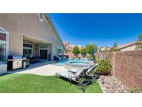 Inviting backyard retreat featuring a sparkling pool, spa, lounge chairs, and lush landscaping at 5820 Amber Station Ave, Las Vegas, NV 89131