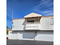 Inviting townhouse featuring a private balcony above three garage doors and stucco facade at 8452 Boseck Dr # 216, Las Vegas, NV 89145