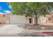 Charming single story home with an attached two car garage and mature shade tree in front yard at 1069 Silver Bullet Ct, Henderson, NV 89011