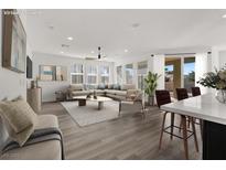 Bright, open living room with a large sectional sofa, neutral decor and wood flooring at 2555 Hampton Rd # 10104, Henderson, NV 89052