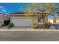 Tan single-story home featuring a red tile roof, low maintenance landscaping, and attached two-car garage at 2852 Red Ct, Las Vegas, NV 89123