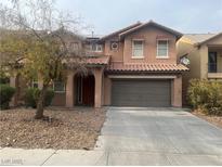 Two-story home featuring a tile roof, two-car garage, and neutral stucco exterior with a low maintenance yard at 3412 Sunrise Rose Ave, North Las Vegas, NV 89031