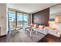 Modern living room features floor to ceiling windows and a comfortable seating arrangement with views of the city at 4381 W Flamingo Rd # 27308, Las Vegas, NV 89103