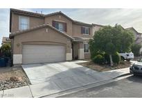 Two-story home features a two-car garage and a well-maintained front yard with mature landscaping and a long driveway at 5549 Green Ferry Ave, Las Vegas, NV 89131