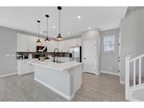 Bright kitchen featuring white cabinets, pendant lighting, stainless steel appliances, and a large center island at 8349 Pollenzo Ave, Las Vegas, NV 89178