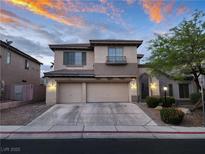 Charming two-story home featuring a three-car garage, desert landscaping, and gorgeous sunset skies at 9052 Pine Mission Ave, Las Vegas, NV 89143