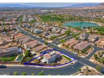 Stunning aerial view of a home with a pool, lush landscaping, and community lake at 301 Resolute Ave, Henderson, NV 89011
