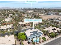 Aerial view of home on Purple Majesty Ct. featuring a pool, solar panels and a view of the Las Vegas strip at 2209 Purple Majesty Ct, Las Vegas, NV 89117