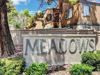 View of the Meadows community sign surrounded by greenery and trees on a sunny day at 5220 Mission Carmel Ln # 101, Las Vegas, NV 89107